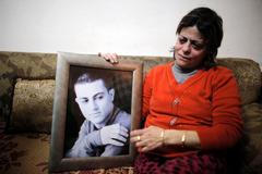 File photo of the mother of Muhammad Musallam, an Israeli Arab held by Islamic State in Syria as an alleged spy, weeping as she holds his photograph in her East Jerusalem home