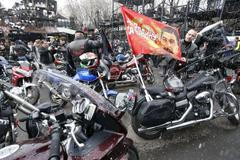 Man adjusts a flag before a farewell ceremony to see off participants of a bike ride at a bike centre in Moscow