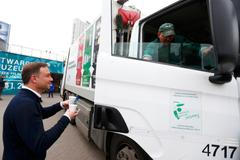 Andrzej Duda podává kávu řidiči nákladního auta s odpadky ve Varšavě.