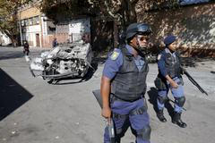 Jihoafrická policie u vraku auta, které shořelo přinepokojích v Johannesburgu.