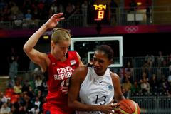 Česká basketbalistka Kateřina Elhotová blokuje Angolku Nacisselu Mauriciovou v utkání skupiny A na OH 2012 v Londýně.