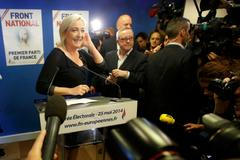 Journalists surround Marine Le Pen, France's National Front political party head, who reacts to results after the polls closed in the European Parliament elections at the party's headquarters in Nante