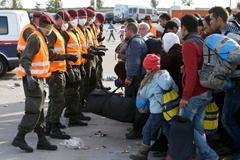 Rakouští vojáci a uprchlíci na rakousko-maďarském přechodu v Nickelsdorfu.