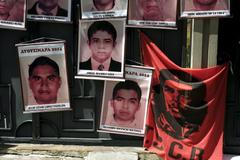 Pictures of the 43 Mexican students who disappeared a year ago are seen hung up near a banner of a revolutionary leader Che Guevara, on the entrance gate of the Mexican embassy in La Paz, Bolivia