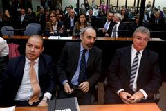 Former Argentine federal judge Galeano sits in court flanked by two unidentified attornies in Buenos Aires