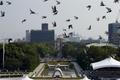 Doves fly over Peace Memorial Park with Atomic Bomb Dome in the background, at a ceremony in Hiroshima