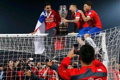 Chile celebrates with the trophy on the goal after defeating Argentina to win the Copa America 2015 final soccer match at the National Stadium in Santiago