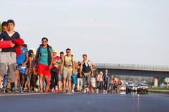 Migrants march along the highway towards the border with Austria