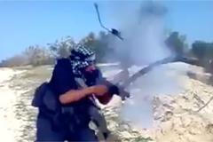 Bojovník IS střílí ze samopalu. Ten mu v rukou exploduje