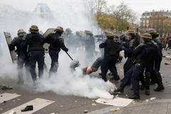 French CRS riot police apprehend a demonstrator during clashes near the Place de la Republique after the cancellation of a planned climate march ahead of the World Climate Change Conference 2015 in P