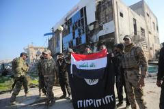 Iráčtí vojáci v dobytém Ramádí. Vlajku Islámského státu narazují iráckou.