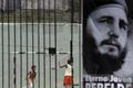 Children play soccer behind a picture of Cuba's former president Fidel Castro in Havana