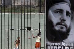 Children play soccer behind a picture of Cuba's former president Fidel Castro in Havana