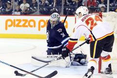 Ondřej Pavelec zasahuje proti střele Jiřího Hudlera