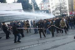 Protesters run from water cannon and tear gas used by riot police to disperse them during a protest in Istanbul