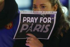 A woman holds a sign during a ceremony in solidarity with the victims the day after a series of deadly attacks in the French capital of Paris, in Lausanne