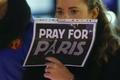 A woman holds a sign during a ceremony in solidarity with the victims the day after a series of deadly attacks in the French capital of Paris, in Lausanne