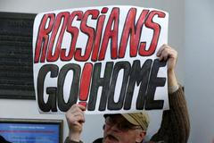 A man holds a placard during the opposition meeting against the deployment of Russian military bases in Minsk