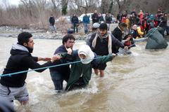 Uprchlíci na řecko-makedonské hranici obcházejí plot a hledají si vlastní cestu.