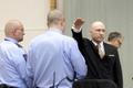Breivik hajluje Mass killer Anders Behring Breivik raises his arm in a Nazi salute as he enters the court room in Skien prison
