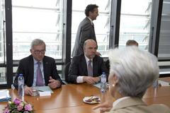 Výkonná ředitelka MMF Christine Lagardeová (zády) a předseda Evropské komise Jean-Claude Juncker (vlevo) čekají na příjezd řeckého premiéra Alexise Tsiprase