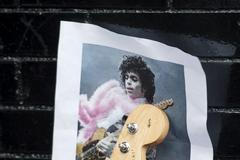 A photo of Prince is held up by a guitar leaning against First Avenue, the nightclub where U.S. music superstar Prince got his start in Minneapolis, Minnesota