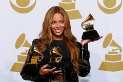 Beyonce holds the awards she won for Best R&B Performance and Best R&B Song for "Drunk in Love" and Best Surround Sound Album for "Beyonce" in the press room at the 57th an