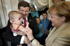 Turecký premiér Ahmet Davutoglu a německá kancléřka Angela Merkelová v uprchlickém táboře.