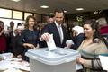 Syria's President Bashar al-Assad casts his vote next to his wife Asma inside a polling station during the parliamentary elections in Damascus