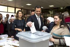 Syria's President Bashar al-Assad casts his vote next to his wife Asma inside a polling station during the parliamentary elections in Damascus