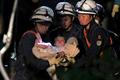 Baby is carried away by rescue workers after being rescued from her collapsed home caused by an earthquake in Mashiki town, Kumamoto prefecture, Japan
