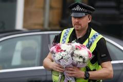 Policista přináší květiny k místu, kde byla zavražděna poslankyně Jo Coxová.