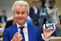 Dutch far-right Party for Freedom leader Geert Wilders shows the picture of the photographers he took with his cell phone prior to his trial in the courtroom in the courthouse in Schiphol