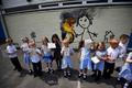 Reception class school children show off their drawings of a mural attributed to Banksy in Bristol