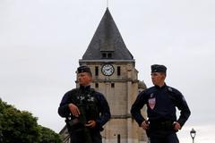 French CRS police stand guartd in front of the church a day after a hostage-taking in Saint-Etienne-du-Rouvray near Rouen in Normandy