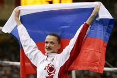 Russia's Svetlana Khorkina celebrates with her national flag