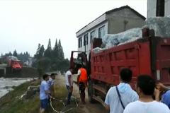 Nákladní auta plná kamení padala do protržené hráze. Řidiči z nich museli vyskakovat