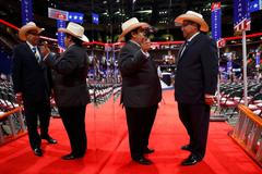 Sjezd republikánů Texas delegates are reflected in a mirror as they talk on the floor during the first day of the Republican National Convention in Cleveland