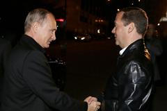 Ruský prezident Vladimir Putin a premiér Dmitrij Medvěděv se zdraví před volebním štábem Jednotného Ruska.