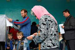 Žena si prohlíží hlasovací lístek ve volební místnosti v jihoruském Stavropolu.