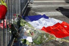 Francouzská vlajka a květiny na promenádě v Nice dva dny po teroristickém útoku