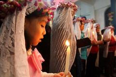 Malá Číňanka se modlí v Chang-čou, v provincii Če-ťiang.