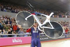 Bradley Wiggins picks up his bicycle as he celebrates after breaking cycling's hour record at the Olympic velodrome in East London, Britain