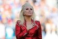 Lady Gaga places her hand over her heart after singing the U.S. National Anthem before the start of the NFL's Super Bowl 50 football game between the Carolina Panthers and the Denver Broncos in Santa