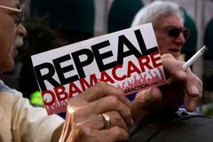 Demonstrant drží ceduli "Zrušte Obamacare".