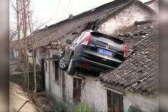 Řidič SUV vyskočil s autem ze silnice na střechu domu. Musel počkat na žebřík