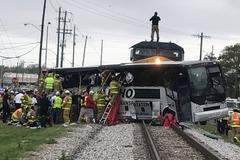 Hasiči pomáhají cestujícím po srážce vlaku s autobusem v americkém Biloxi.