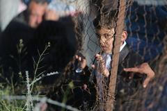 Palestinský chlapec čeká, až dostane povolení přejít s rodinou do Egypta.