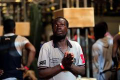 Modlící se migrant, kterého zachránili ze Středozemního moře.