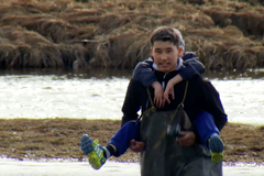 Starší děti přenášejí mladší přes řeku. Jinak by se nedostaly do školy